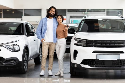 Smiling,Millennial,Indian,Couple,Standing,Next,To,New,White,Car,